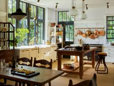 a kitchen filled with lots of counter top space and wooden chairs next to a dining room table