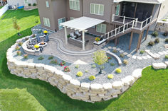 an aerial view of a large house with landscaping and patio area in the foreground