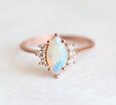 A beautiful marquise opal & diamond ring set made in 14k or 18k gold, pictured in rose gold. A perfect wedding, engagement or bridal set.
The design can be made with gemstones of your choosing.
If you would prefer a custom ring, please contact us before purchase.
Details Main stone Gemstone: Australian opal Cut: marquise Measurements: approx. 10x5mm
Side stones Gemstone: white diamonds Shape: round Measurements: approx. 2mm (2), approx. 1.5mm (4) Quality: clarity grade VS, color grade G, conflic Rose Gold Moonstone Ring, Gold Opal Ring, Gold Moonstone Ring, Rose Gold Opal Ring, Opal Diamond Ring, Opal Engagement Ring, Ring Marquise, Engagement Rings Marquise, Opal Ring Gold