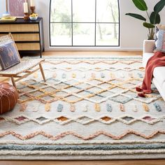 a living room with a large window and rugs on the floor in front of it