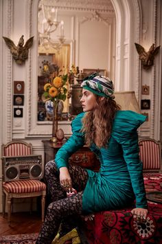 a woman sitting on top of a couch in a room