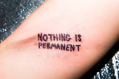 a tattoo saying nothing is permanentment on someone's left arm with the word