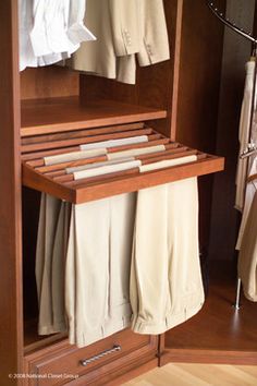 a wooden shelf with clothes hanging on it