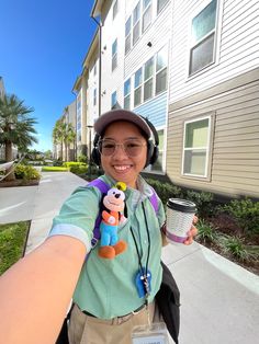 a woman with headphones and a backpack holding a cup