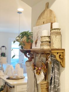 a shelf filled with baskets and other items on top of a kitchen counter next to a potted plant