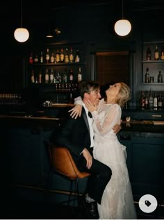 a bride and groom kissing at the bar