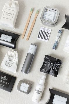 an assortment of personal care items laid out on a white tablecloth, including toothbrushes, soaps, and lotion