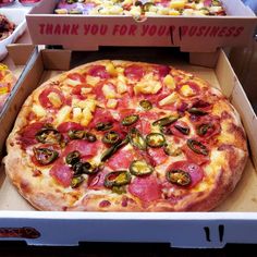 a pizza in a box with many toppings