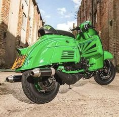 a green motorcycle parked in an alley way