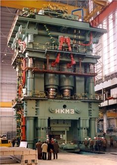 people standing in front of an industrial machine