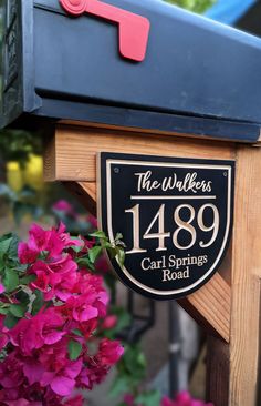 a mailbox with the number 1389 on it next to some flowers and bushes