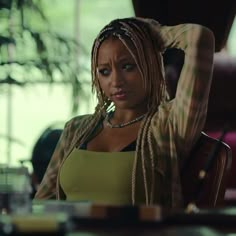 a woman with dreadlocks sitting at a table