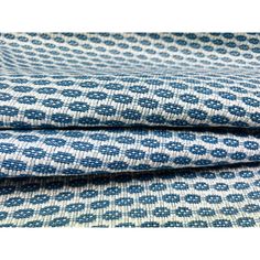 blue and white patterned fabric with small circles on the bottom, one side is folded to show