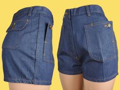 "Like new crisp dark wash twill denim shorts with a mid to high rise & short cut. To me, the fit is cute, but they're really all about the pockets! They're all flap patch pockets with buttons, but the 2 in front are so unique as the pocket can unbutton into a diagonal flap & are still accessible buttoned up. There are moderate belt loops & a robust metal zip fly with a button closure. The topstitching is burnt orange. ♡ LABELS & SIZING Made in the 70s in Thailand. There's not any branding anywhe Fitted High Rise Shorts With Hip Pockets, High Rise Fitted Shorts With Hip Pockets, Fitted High Waist Shorts With Hip Pockets, Retro Cotton Cutoff Shorts, Fitted Cotton Jean Shorts With Pockets, Fitted Denim Jean Shorts With Belt Loops, Fitted Medium Wash Shorts With Pockets, Fitted Dark Wash Jean Shorts With Pockets, Retro Short Denim Shorts