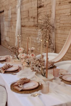 the table is set with place settings and flowers