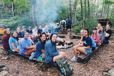 a group of people sitting around a campfire