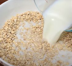 pouring milk into a bowl of oatmeal