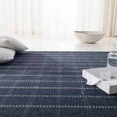 a living room with a blue rug and water bottle on the floor next to it