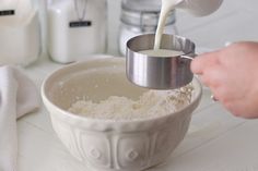 a person pouring milk into a bowl