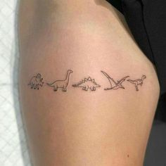 a woman's thigh with three small dinosaurs on it