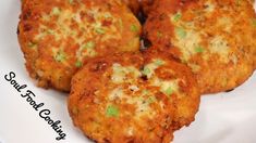 three crab cakes on a white plate with green onions