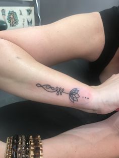 two women with matching tattoos on their legs, one is holding the other's hand