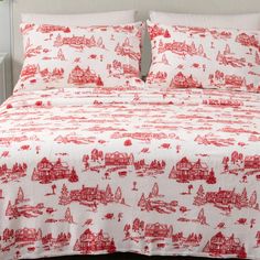 a bed with red and white bedspread on top of it