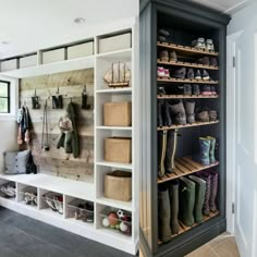 the inside of a shoe closet with several pairs of boots hanging on it's shelves