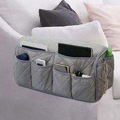 a purse hanging from the back of a couch with some items in it and other things inside