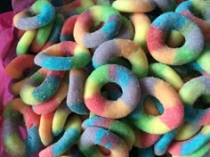 a pile of colorful donuts sitting on top of a pink bag