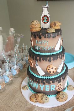 a three tiered cake with cookies and cookie decorations on the top is sitting on a table