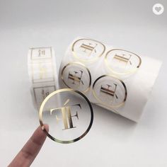 a hand holding a magnifying glass in front of some stickers with the letter t on them