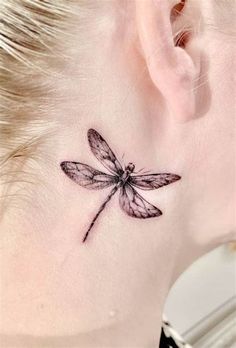 a small dragonfly tattoo on the ear