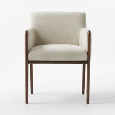 an upholstered chair with wooden legs and armrests