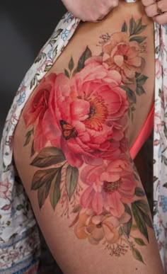 a close up of a woman's thigh with flowers on it