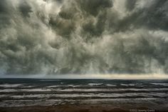 the sky is very dark and cloudy over the ocean as it moves through the water