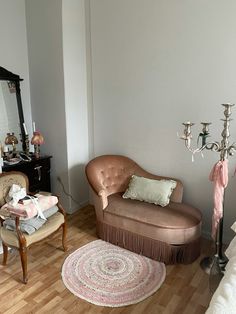 a living room filled with furniture and a chandelier hanging from the ceiling over a wooden floor