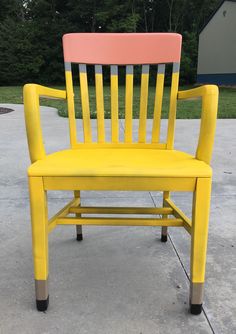 a yellow and pink chair sitting on concrete