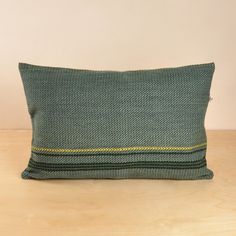 a green pillow sitting on top of a wooden table