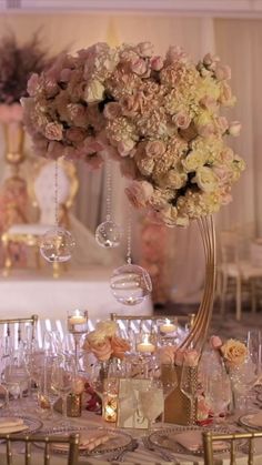 the table is set with many glasses and flowers in vases on top of it