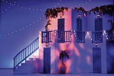 a white building with lights on the balconies