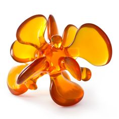 an orange glass flower sculpture sitting on top of a white surface