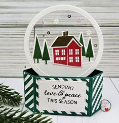 a christmas ornament with a red house on it