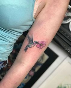 a woman with a hummingbird tattoo on her arm