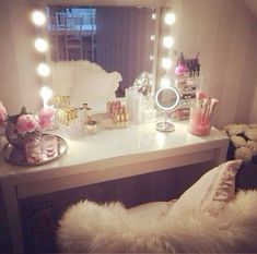 a vanity with lighted lights and flowers on it