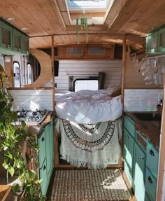 the interior of a small camper with green cabinets and wood flooring is shown