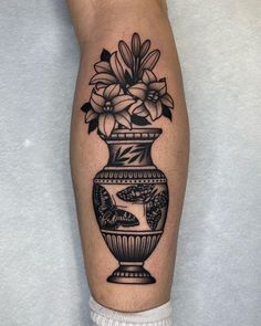 a black and white vase with flowers in it on the right calf sleeve tattoo design