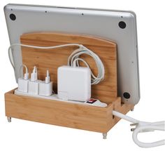 an electronic device charging in a wooden holder with cords and plugs attached to it