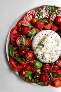 a white plate topped with tomatoes and cheese