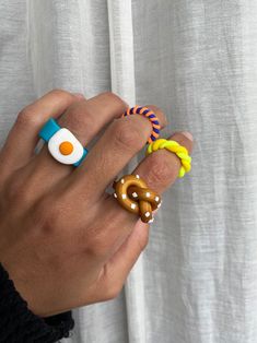 a person wearing rings with an egg on top and two pretzels in the middle